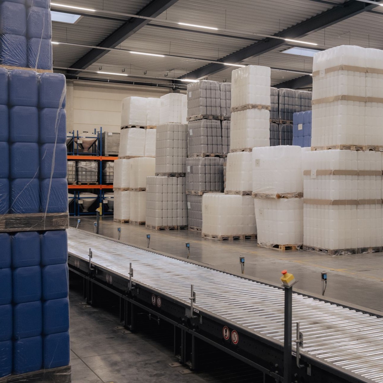 Lagerort für Stapelkanister mit Förderband im Vordergrund