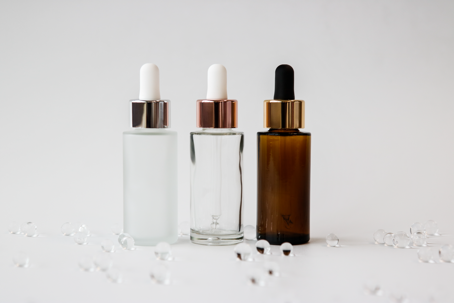 Silberne Pipettenmontur mit säuremattierterKosmetikflasche, durchsichtige Kosmetikflasche mit rosegoldener Pipettenmontur, Braunglas Kosmetikflsche mit goldener Pipettenmontur