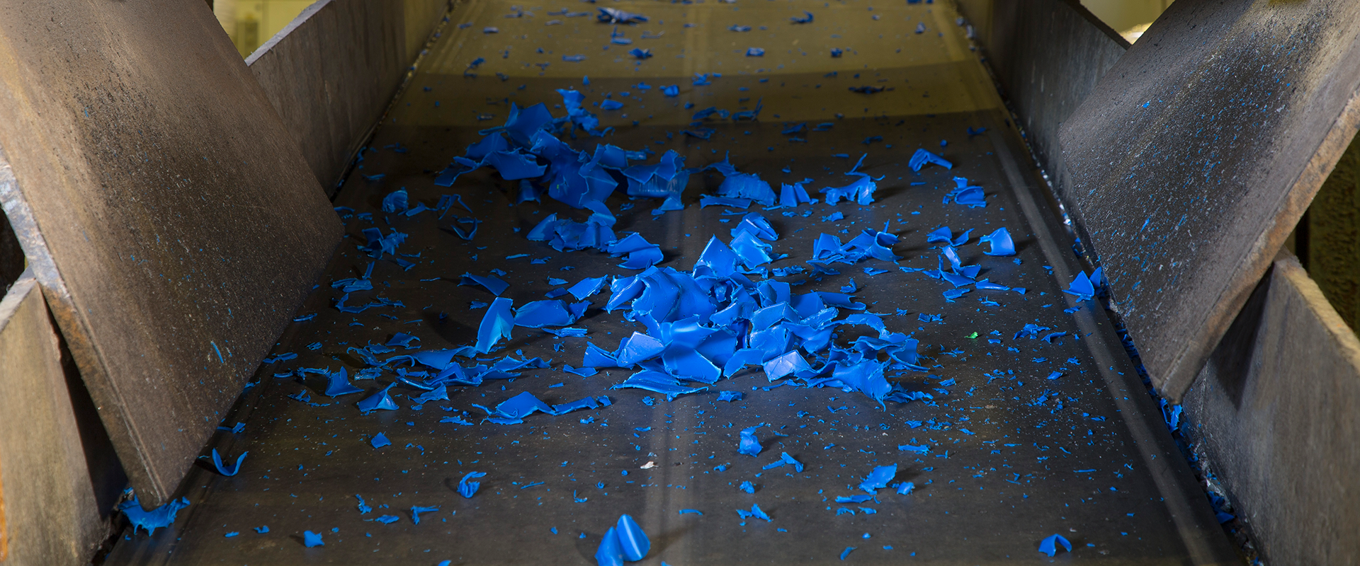 Auf einem Förderband befindet sich recycelter Kunststoff.