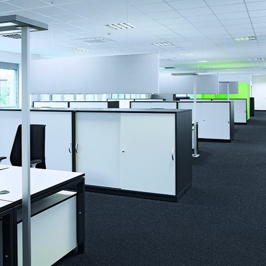 Großraumbüro mit hellen Schreibtischen und Schränke als Abtrenner