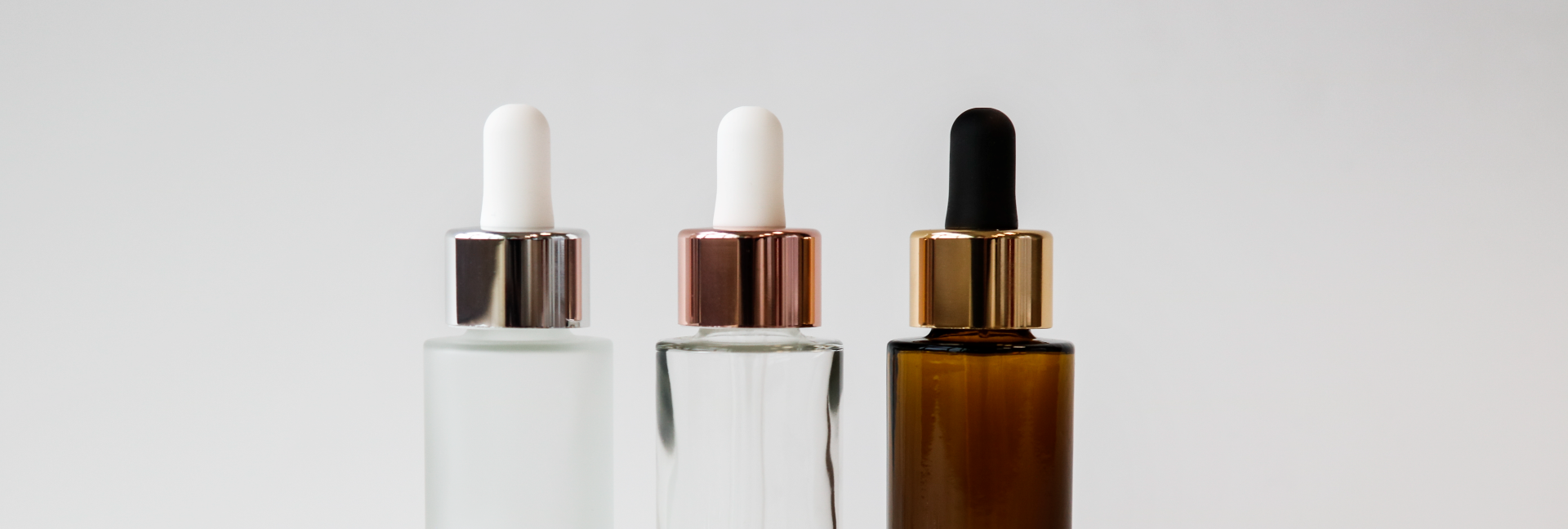 Silberne Pipettenmontur mit säuremattierterKosmetikflasche, durchsichtige Kosmetikflasche mit rosegoldener Pipettenmontur, Braunglas Kosmetikflsche mit goldener Pipettenmontur