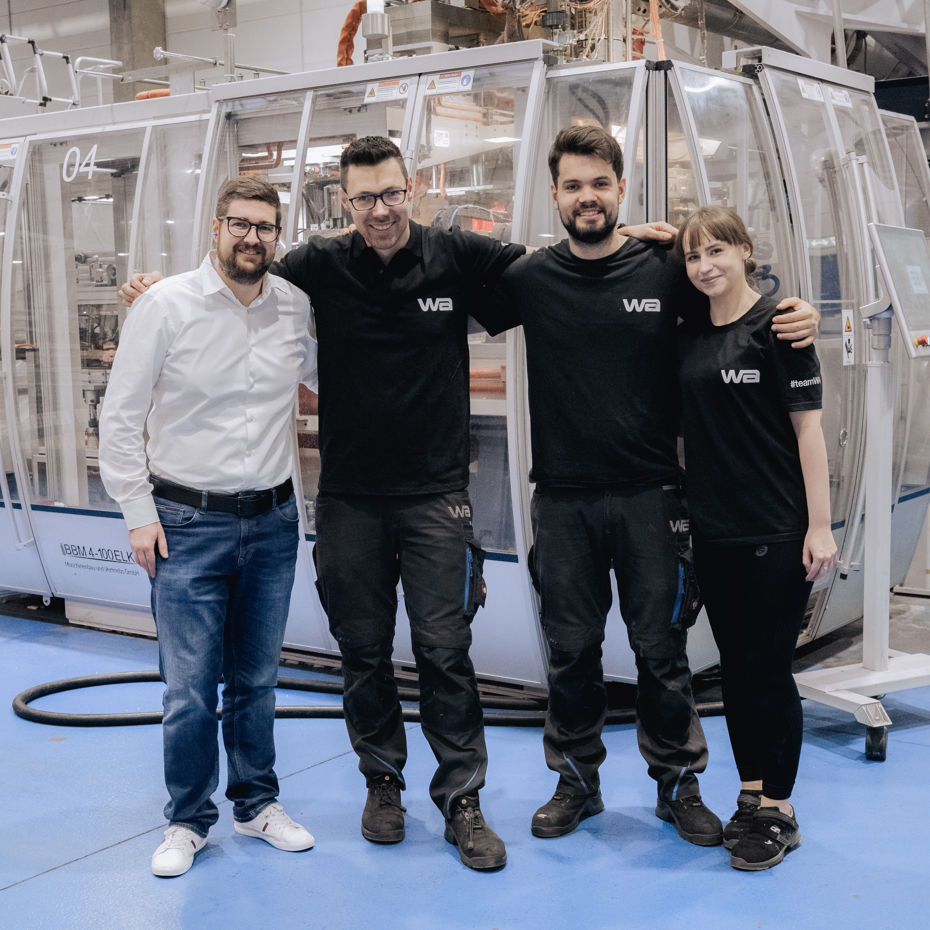 Team in einer Reihe vor Maschine