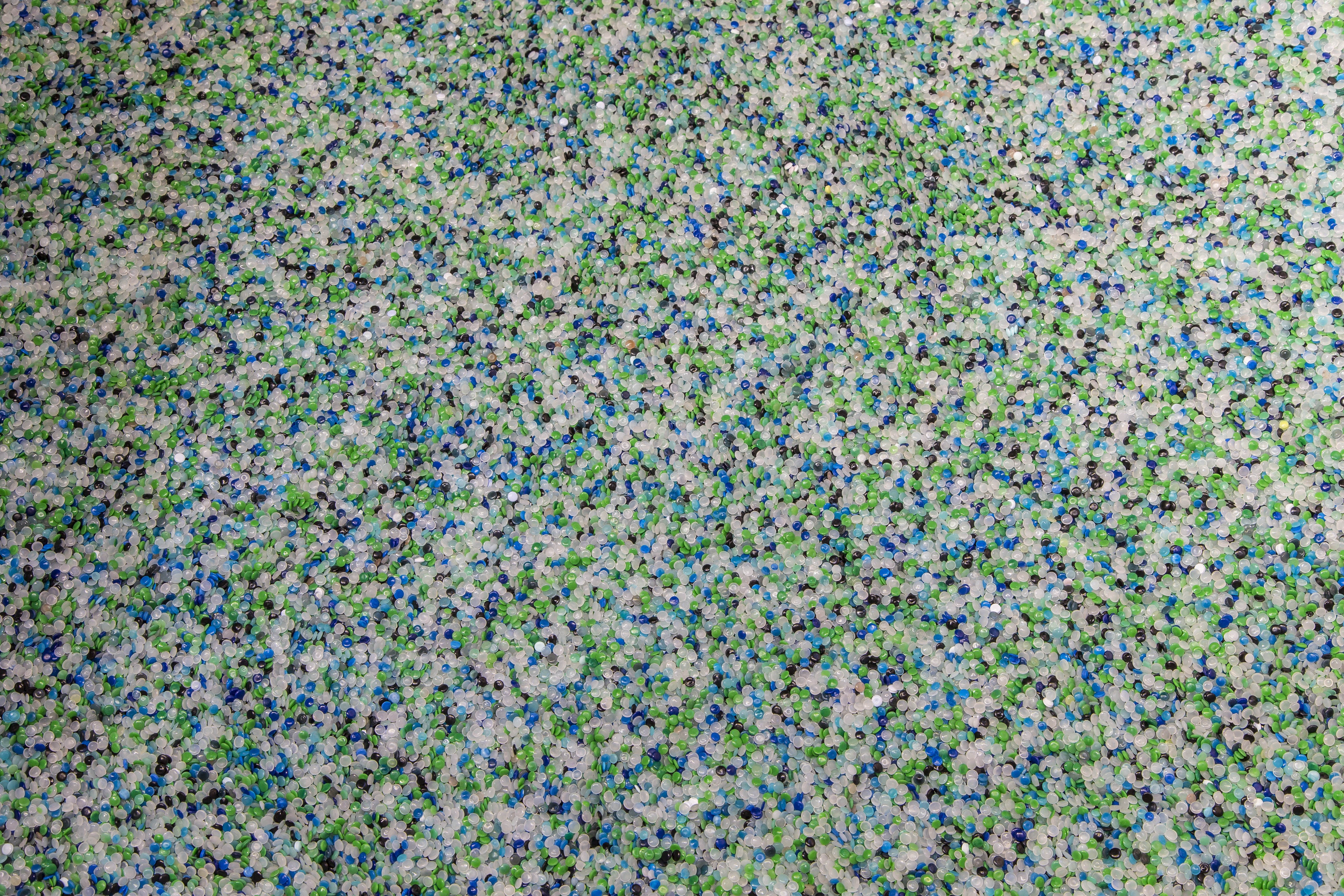 Kleine Flocken Kunststoff in grün, weiß, blau und schwarz