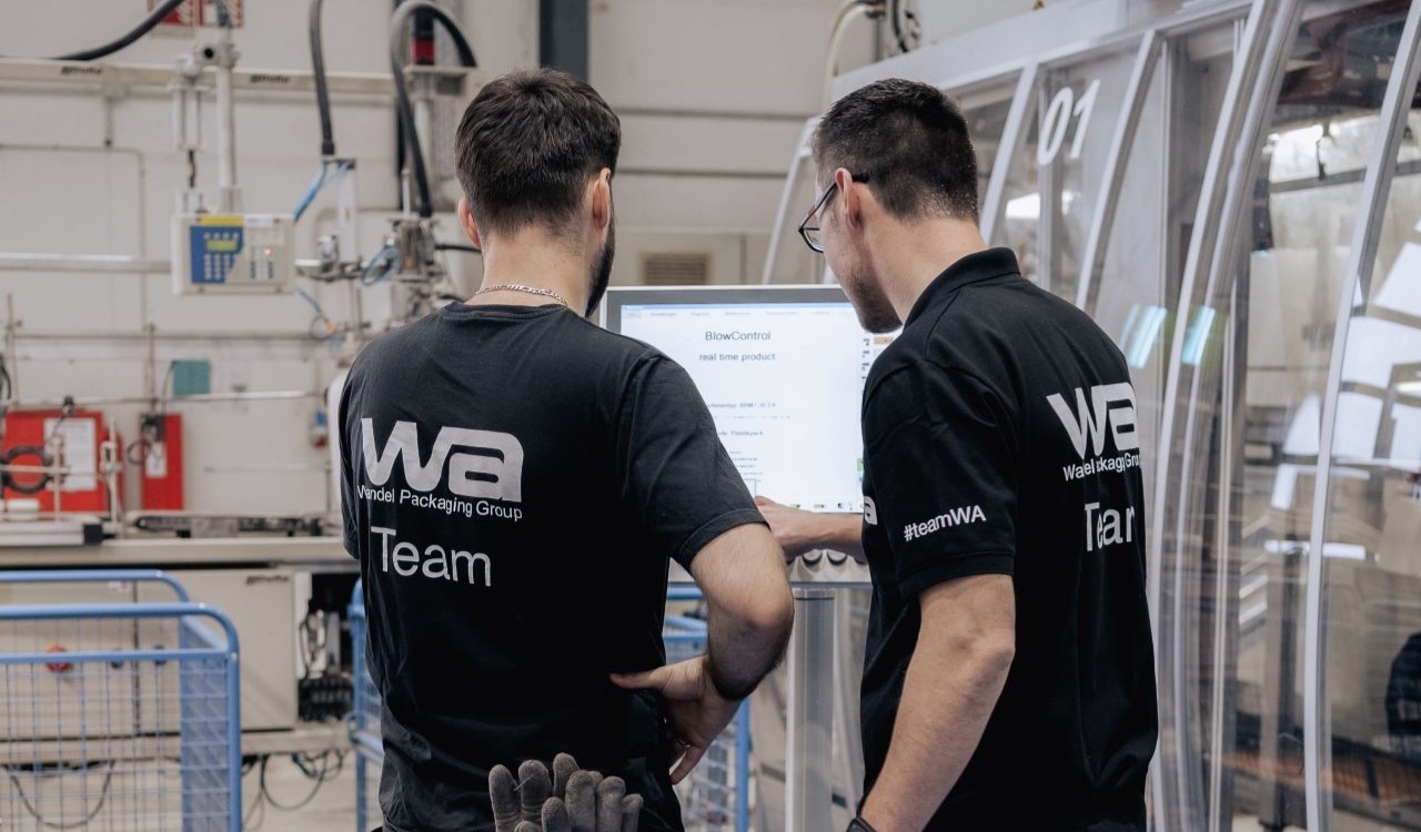 Zwei Kollegen bei der Bedienung einer Maschine